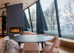 Aurora Lodge 2 à structure hybride avec de grandes baies vitrées panoramiques et un feu de cheminée